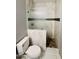 A modern bathroom showcasing a toilet and tiled shower with glass door and dark accent tiles at 32101 W Palo Verde St, Wittmann, AZ 85361