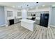 Bright kitchen features gray cabinets, stainless appliances, kitchen island and modern lighting at 32101 W Palo Verde St, Wittmann, AZ 85361