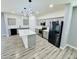 Bright kitchen features gray cabinets, stainless appliances, kitchen island and modern lighting at 32101 W Palo Verde St, Wittmann, AZ 85361