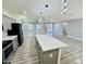 Open-concept living room and kitchen space with modern lighting and wood-look floors at 32101 W Palo Verde St, Wittmann, AZ 85361