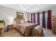 Comfortable bedroom with neutral walls, a ceiling fan, and ample natural light through sheer red curtains at 34 Leisure World --, Mesa, AZ 85206