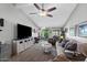 A cozy living room features a vaulted ceiling, ceiling fan, and sliding door to the backyard at 34 Leisure World --, Mesa, AZ 85206