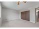 Spacious carpeted bedroom with ceiling fan and closet, next to the doorway at 3407 E Pueblo Ave, Mesa, AZ 85204