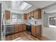 Well-lit kitchen boasting modern appliances, wood-tone cabinetry, and a bright skylight at 3407 E Pueblo Ave, Mesa, AZ 85204