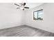 Bright bedroom features new gray floors, a ceiling fan, and ample natural light from a window at 3556 E Angela Dr, Phoenix, AZ 85032