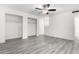 Cozy bedroom with new gray floors, a ceiling fan, and two convenient storage closets for your organizational needs at 3556 E Angela Dr, Phoenix, AZ 85032