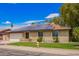 Attractive home with a well-kept lawn, brick facade, and modern solar panels at 3556 E Angela Dr, Phoenix, AZ 85032