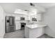 A modern kitchen featuring stainless steel appliances, white cabinetry, bright lighting, and a breakfast bar for casual dining at 3556 E Angela Dr, Phoenix, AZ 85032