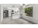 Modern white kitchen with stainless steel appliances, a breakfast bar and lots of light at 3556 E Angela Dr, Phoenix, AZ 85032