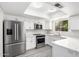 A modern kitchen featuring stainless steel appliances, white cabinetry, bright lighting, and a breakfast bar for casual dining at 3556 E Angela Dr, Phoenix, AZ 85032