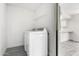 Clean, well-lit laundry room with modern white appliances and storage shelving at 3556 E Angela Dr, Phoenix, AZ 85032