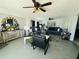 A spacious living room featuring two sofas, multiple ceiling fans, and decorative mirrors and lighting at 3806 N 80Th Dr, Phoenix, AZ 85033