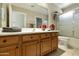 Well-lit bathroom featuring a wood vanity, large mirror, and a shower with glass doors at 4202 E Broadway Rd # 40, Mesa, AZ 85206