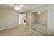 Spacious bedroom with plush carpet, a ceiling fan, and mirrored closet doors at 4202 E Broadway Rd # 40, Mesa, AZ 85206