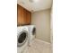 Functional laundry room with washer, dryer, tile floors, and storage cabinets at 4202 E Broadway Rd # 40, Mesa, AZ 85206