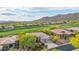 Aerial view of a home with solar panels, a golf course, and mountain backdrop at 42102 N Long Cove Way, Phoenix, AZ 85086
