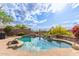 Beautiful pool with rock waterfall feature, lush landscaping, and a fence for safety at 42102 N Long Cove Way, Phoenix, AZ 85086