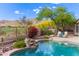 Landscaped backyard with pool featuring rock waterfall, lush trees, and golf course view at 42102 N Long Cove Way, Phoenix, AZ 85086