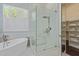 Bathroom featuring a soaking tub, glass shower, marble accents, and a walk-in closet at 42102 N Long Cove Way, Phoenix, AZ 85086