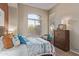 Cozy bedroom featuring two windows, neutral walls, and an upholstered bed frame at 42102 N Long Cove Way, Phoenix, AZ 85086
