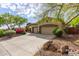 Spacious driveway leading to a three-car garage, framed by mature trees and manicured landscaping at 42102 N Long Cove Way, Phoenix, AZ 85086