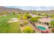 Aerial view shows the manicured golf course in a desert landscape, with mountain views, in a residential community at 42102 N Long Cove Way, Phoenix, AZ 85086