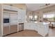 Open-concept kitchen with stainless steel refrigerator and white cabinetry, connected to the backyard view at 42102 N Long Cove Way, Phoenix, AZ 85086