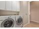 Convenient laundry room with front load washer and dryer and built-in cabinets at 42102 N Long Cove Way, Phoenix, AZ 85086