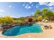 Stunning backyard pool with rock waterfall feature and views of the golf course and mountains at 42102 N Long Cove Way, Phoenix, AZ 85086