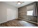 Stylish bedroom with an accent wall, wood look flooring, a ceiling fan, and a sliding door closet at 4336 E Mesquite St, Gilbert, AZ 85296