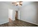 This bedroom features wood look floors, neutral walls, a ceiling fan, and a view into the closet and bathroom at 4336 E Mesquite St, Gilbert, AZ 85296