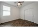 Bedroom with sleek wood-look floors, a ceiling fan, and a closet behind sliding doors at 4336 E Mesquite St, Gilbert, AZ 85296