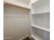 A walk-in closet with ample storage space featuring sturdy shelves and a wooden clothes rod for hanging at 4336 E Mesquite St, Gilbert, AZ 85296