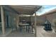 Covered patio with outdoor dining set, grill, and a lantern at 43914 W Wade Dr, Maricopa, AZ 85138