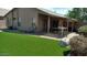 Fenced backyard, featuring synthetic grass, patio, and exterior of home at 43914 W Wade Dr, Maricopa, AZ 85138