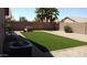 Backyard with artificial grass, desert landscaping and a brick wall at 43914 W Wade Dr, Maricopa, AZ 85138