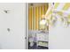 Chic bathroom with yellow striped wallpaper, a round mirror, and white fixtures, blending fun design with functionality at 4502 E Solano Dr, Phoenix, AZ 85018