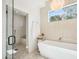 Serene bathroom with a soaking tub, glass-enclosed shower, and elegant tile work at 4502 E Solano Dr, Phoenix, AZ 85018