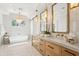 Modern bathroom featuring dual sinks, stylish light fixtures, hexagon tile floor, and a freestanding soaking tub at 4502 E Solano Dr, Phoenix, AZ 85018
