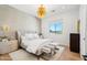 Inviting bedroom with a stylish bed, modern lighting fixtures, and a peaceful view from the large window at 4502 E Solano Dr, Phoenix, AZ 85018