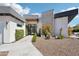 Modern home exterior with desert landscaping, a stone facade, and a sleek design, creating a stylish curb appeal at 4502 E Solano Dr, Phoenix, AZ 85018