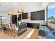 Open kitchen and dining space with granite countertops, island seating, and modern appliances at 4502 E Solano Dr, Phoenix, AZ 85018