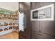 Open pantry and kitchen, complete with stainless steel microwave and custom dark cabinetry at 4502 E Solano Dr, Phoenix, AZ 85018