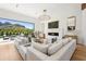 Open-concept living room with a modern fireplace, plush seating, and expansive windows offering picturesque views at 4502 E Solano Dr, Phoenix, AZ 85018