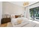 Light-filled main bedroom featuring a contemporary chandelier, warm accents, and a sliding glass door at 4502 E Solano Dr, Phoenix, AZ 85018