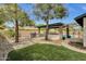 Expansive backyard featuring a built-in grill, covered patio, pool, mature trees, and artificial turf for outdoor enjoyment at 4840 E Sunnyside Dr, Scottsdale, AZ 85254