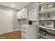 Functional laundry room featuring white cabinets, shelving, modern storage, and light wood-style flooring at 4840 E Sunnyside Dr, Scottsdale, AZ 85254