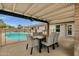 Covered patio with comfortable seating, dining table, and views of the sparkling swimming pool in the backyard at 4840 E Sunnyside Dr, Scottsdale, AZ 85254