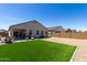 A manicured backyard features an artificial lawn, patio, and low-maintenance gravel landscaping at 5146 E Diatomite Dr, San Tan Valley, AZ 85143