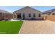 A view of the backyard with artificial lawn, stone landscaping, and patio with an outdoor dining set at 5146 E Diatomite Dr, San Tan Valley, AZ 85143